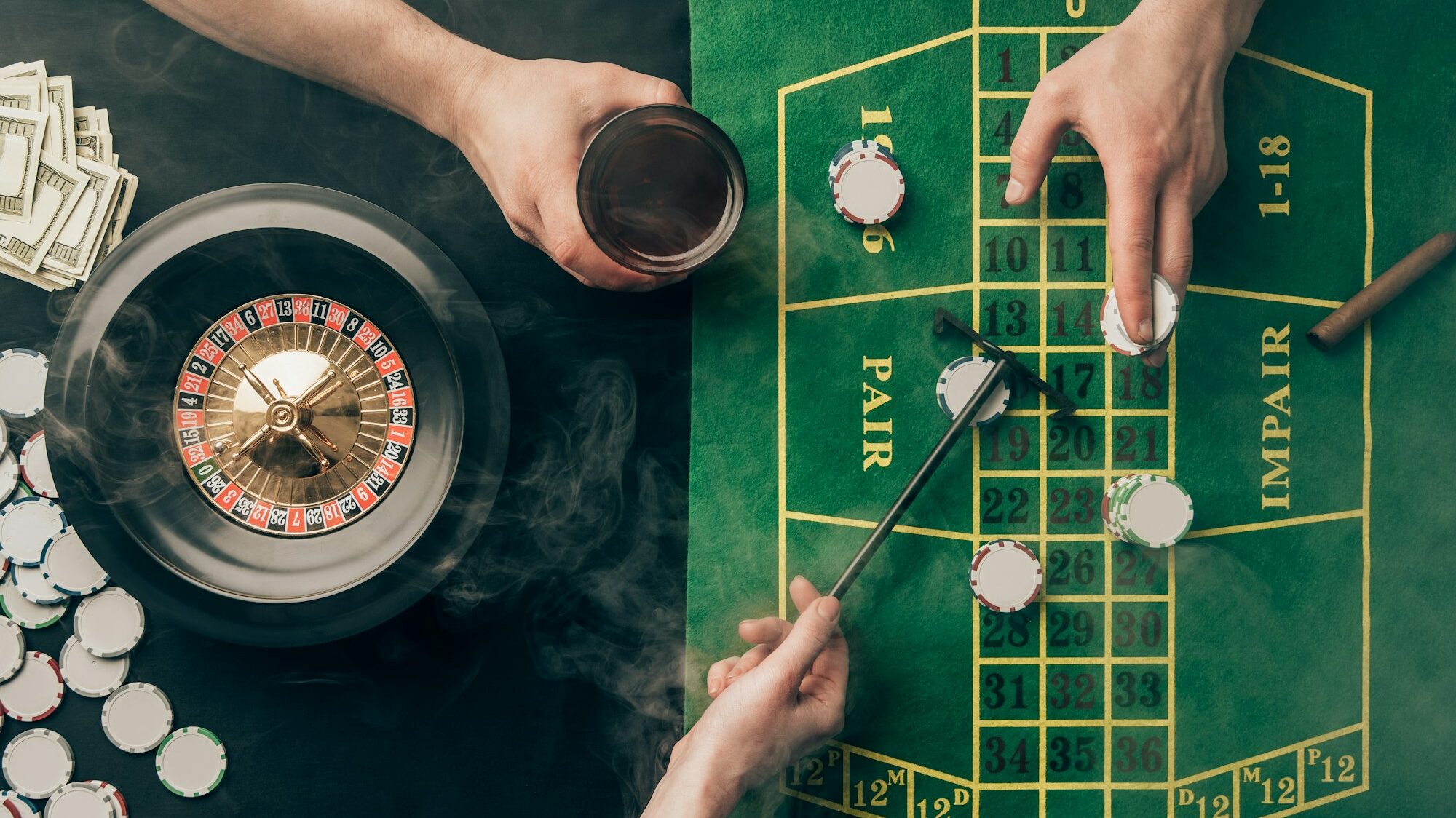 Smoke over people placing bets while playing roulette on casino table