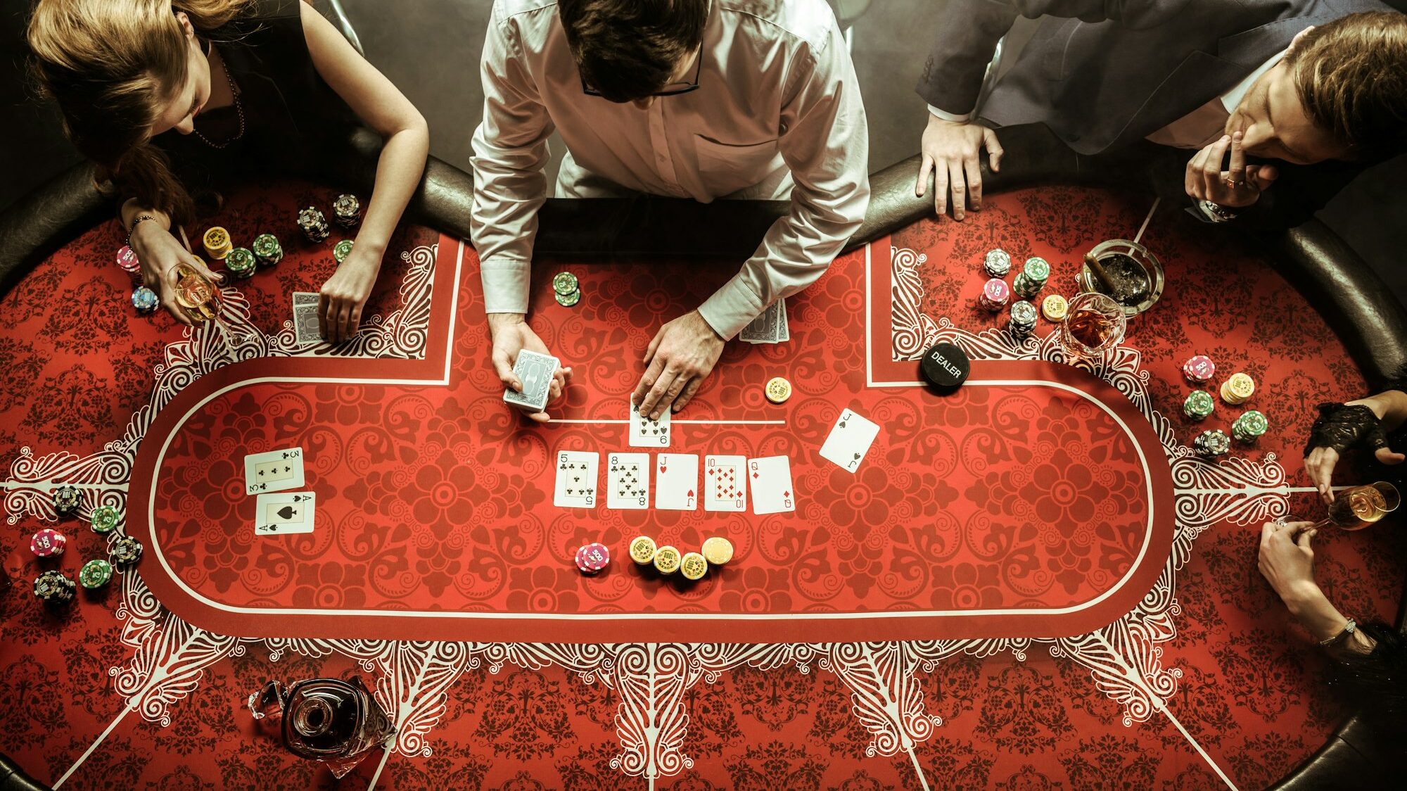 top view of men and women playing poker in casino